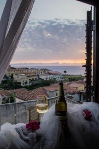 a bottle of wine sitting on a balcony overlooking a beach at B&B Villa San Nicola in San Nicola Arcella
