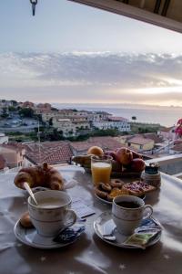 een tafel met kopjes koffie en gebak erop bij B&B Villa San Nicola in San Nicola Arcella