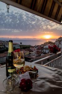 een glas wijn op een tafel met uitzicht op de zonsondergang bij B&B Villa San Nicola in San Nicola Arcella