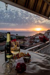 a glass of wine on a table with a view of the sunset at B&B Villa San Nicola in San Nicola Arcella