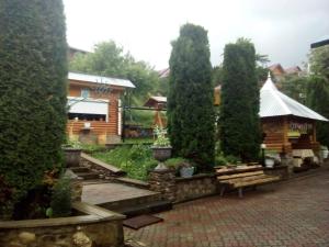 un jardín con árboles y una cabaña de madera en Садиба у Власія, en Putyla