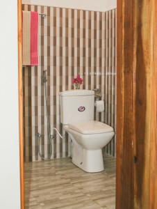 a bathroom with a toilet and a shower at Garden Beach Hotel in Arugam Bay