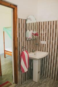 a bathroom with a sink and a red and white towel at Garden Beach Hotel in Arugam Bay