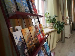 a bunch of books on a shelf in a room at Amber Private Rooms in Riga