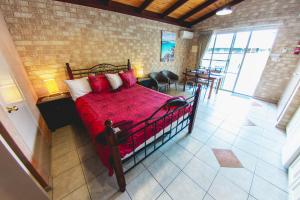 a bedroom with a bed with a red comforter at Esperance Foreshore Apartments in Esperance