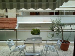 雅典的住宿－薩皮恩酒店，庭院里设有两把椅子和一张桌子