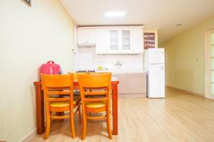 a kitchen with a table and chairs and a refrigerator at Muju Ilsung Condo in Muju