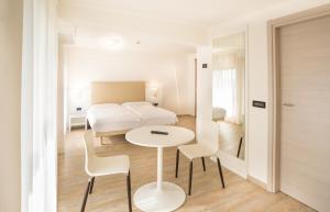 a hotel room with a bed and a table and chairs at Fantinello Hotel in Caorle