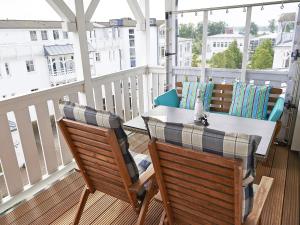 een patio met een tafel en stoelen op een balkon bij Seepark Sellin - Apt. 382 in Ostseebad Sellin