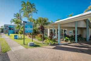 a street sign in front of a building at The Beach Motel Hervey Bay in Hervey Bay