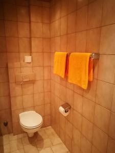 ein Bad mit WC und Handtüchern an der Wand in der Unterkunft Gasthof Stauder in Innsbruck