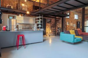 ein Wohnzimmer mit einem blauen Sofa und einem roten Stuhl in der Unterkunft The Loft Unique Designed in Florenz