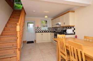 a kitchen with a wooden table and a dining room at Cottage 236 Roundstone in Roundstone