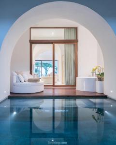 a living room with a white couch and a pool at SALA Samui Chaweng Beach Resort in Chaweng