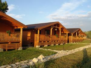 a row of log homes with a dog in front of them at Complex Agroturistic Livada de Nuci in Baia de Fier