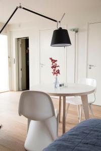 a white dining room with a table and a black lamp at BB Museumquarter in Amsterdam