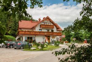 a house with cars parked in front of it at Villa Adamo&SPA in Zakopane
