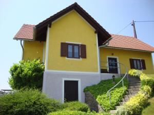 a yellow house with stairs in front of it at Ferienhaus Weingut Bauer in Gamlitz