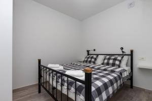 - une chambre avec un lit et un berceau noir dans l'établissement Apartments Siblings, à Mokošica