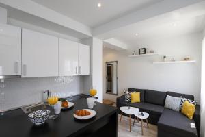 a kitchen and a living room with a black couch at Apartments Siblings in Mokošica