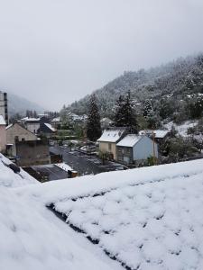 a town covered in snow with a mountain in the background at Appartement Cap Horn in Le Mont-Dore