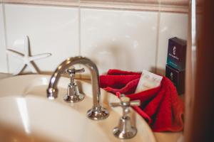 a bathroom sink with two faucets and a red towel at Esperance Foreshore Apartments in Esperance +37 photos