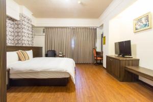 pokój hotelowy z łóżkiem i telewizorem w obiekcie Lech Hotel w mieście Luodong