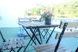 a picnic table with a potted plant and two benches at Mar de Rosas in O Grove