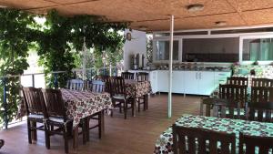 a restaurant with tables and chairs and a kitchen at Ferah Hotel in Patara