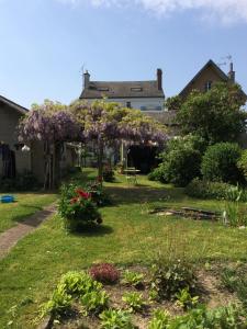 a garden in front of a house with purple flowers at La Pie Grièche in Coucy