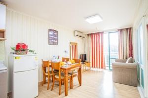a kitchen and dining room with a table and a refrigerator at Jiri Mountain Ilsung Condo in Namwon