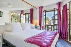a bedroom with a large bed with pink curtains at Logis Hotel & Restaurant Bergeret Sport in Hendaye