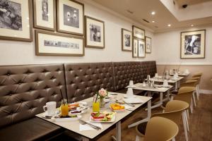 a row of tables in a restaurant with plates of food at Hotel Central Basilica in Budapest