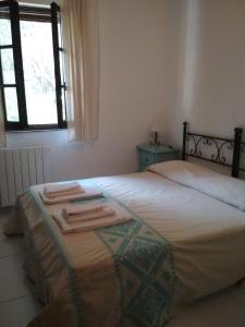 1 dormitorio con 1 cama con toallas en B&B S'Archiotta en Buggerru