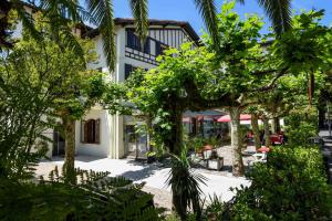 a building with trees in front of it at Logis Hotel & Restaurant Bergeret Sport in Hendaye