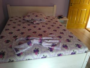 a bed with a flowered comforter on it at Casa Teo in Ocna Sibiului