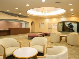 une salle d'attente avec des tables et des chaises dans un hôpital dans l'établissement Itoen Hotel Kusatsu, à Kusatsu