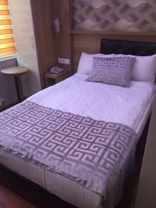 a bedroom with a bed with a white comforter and pillows at Göznur Otel in Bandırma