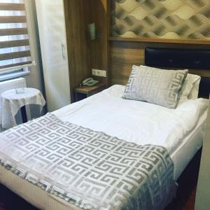 una camera con letto bianco e cuscino di Göznur Otel a Bandırma
