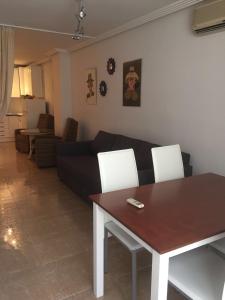 a living room with a table and a couch at Emalco Anis Primera Linea in Benidorm