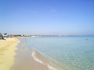 a beach with people swimming in the water at Hotel Don Ferrante in Monopoli