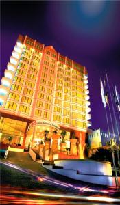 a large yellow building with lights in front of it at Swiss-Belhotel Borneo Samarinda in Samarinda