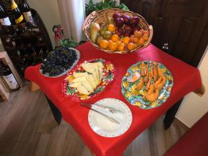 a red table with a basket of fruits and vegetables at L'Arco dei Sogni in Malvagna