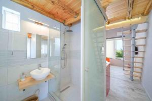 a bathroom with a glass shower and a sink at Kalliston Beach Apartments in Limenas +87 photos