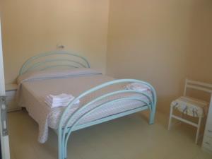 a small bedroom with a blue bed and a chair at Appartamenti Teulada di Laura in Teulada