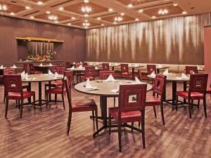 a dining room with tables and red chairs at Hotel Nikko Narita in Narita