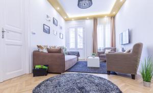 uma sala de estar com um sofá e duas cadeiras em Real Apartments Zoltán em Budapeste