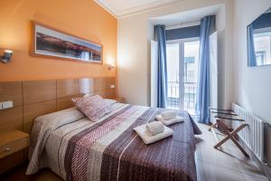 a bedroom with a bed, a desk, and a window at INTER Puerta del Sol Pension in Madrid