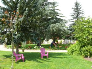 zwei lila Stühle in einem Hof mit Spielplatz in der Unterkunft Gîte du Clos de la Vigne in Montreuil