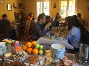 a group of people sitting at a table with food at Casa Rural Sierra de Tormantos in Guijo de Santa Bárbara